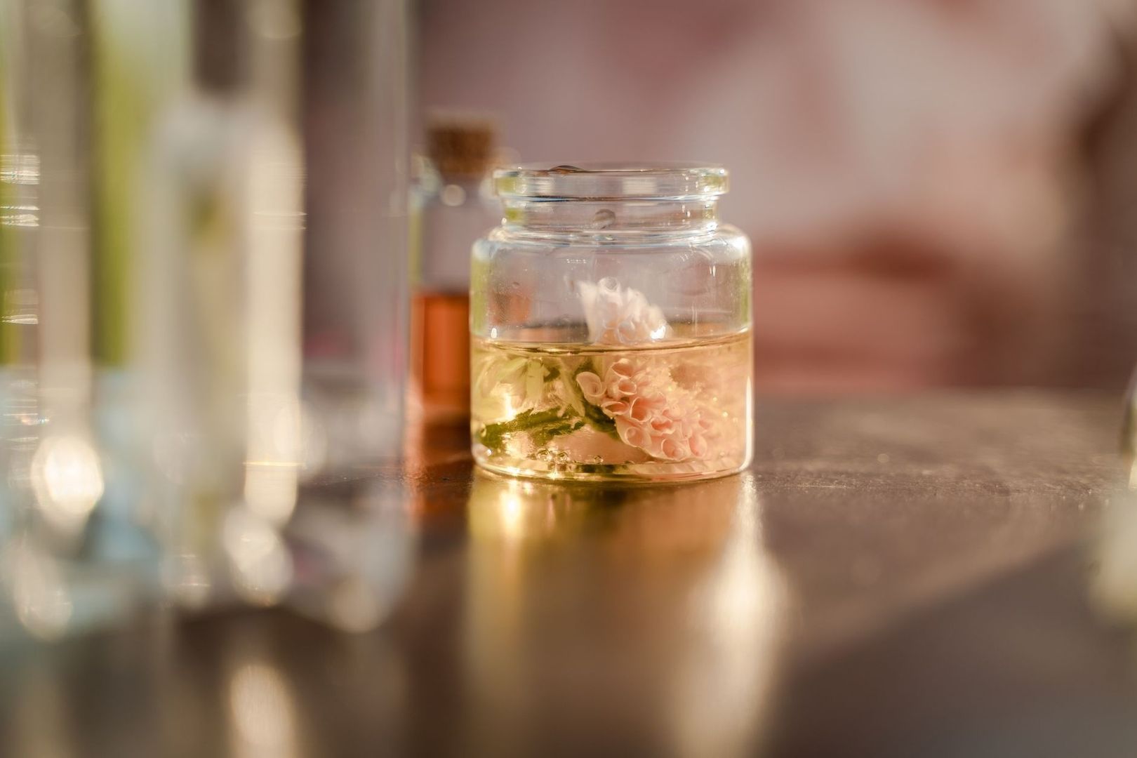 Glasburk med blommor och växtdelar i vätska på ett laboratorium